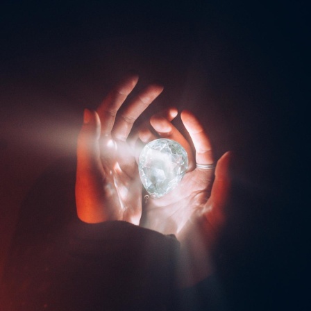 CLOSE-UP OF HUMAN HAND HOLDING ILLUMINATED LIGHT