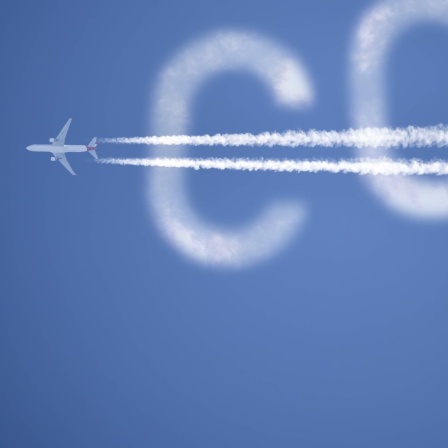 Flugzeug mit Kondensstreifen und Schriftzug CO2 am Himmel