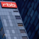 Das beleuchtete Logo des Senders Rundfunk Berlin-Brandenburg (RBB) ist an der Fassade am Sitz des Senders an der Masurenallee angebracht.