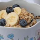 Porridge mit Banane und Blaubeeren in einer Müslischüssel mit Blumenmuster