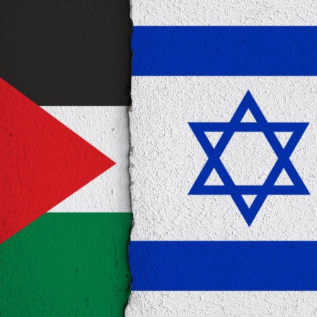 Die Nationalflaggen der Palaestinas und Israels nebeneinander auf einer Wand.