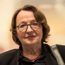 Schrifstellerin Katja Lange-Müller blickt vor orangem Hintergrund in die Kamera