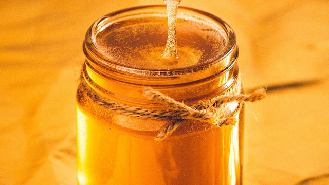 Honig fließt in ein Glas.