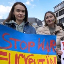 Drei Demonstrantinnen mit Plakaten auf einer Friedensdemo in Bonn