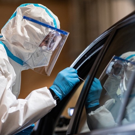 Ein Mitarbeiter nimmt in einem COVID-19-Drive-In-Testzentrum eine Probe