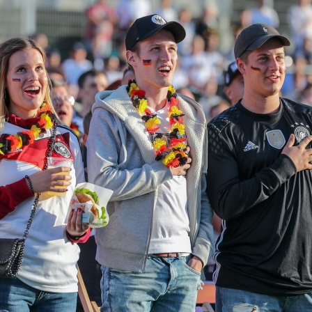 Fans der deutschen Fußball-Nationalmannschaft singen die deutsche Nationalhymne.