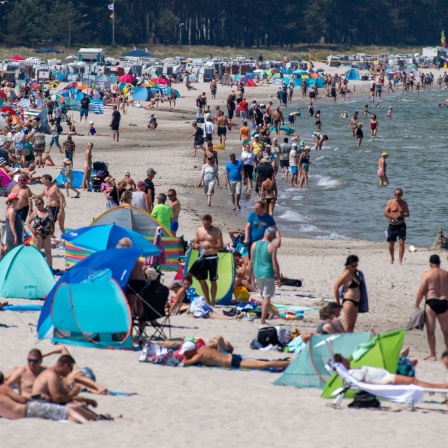Eine große Zahl an Touristen ist bei sonnigem Wetter am Strand der Insel Rügen.
