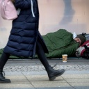 Frau läuft auf dem Kurfürstendamm an schlafendem Obdachlosen vorbei © picture alliance/AP/Michael Sohn