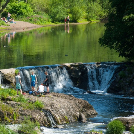 Menschen baden an dem Wasserfall bei Windeck