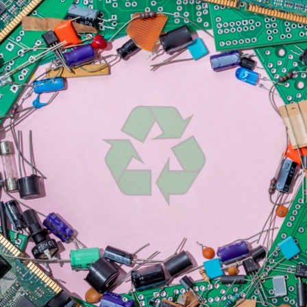 Leiterplatten, Widerstände und andere Elektrobauteile liegen um die Illustration eines Kreislaufwirtschaftszeichens herum.