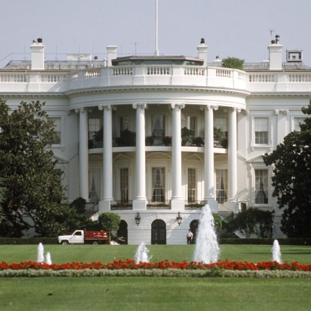 Blick über den Rasen und kleine Fontänen auf das Weiße Haus in Washington D.C., dem Amtssitz des amerikanischen Präsidenten
