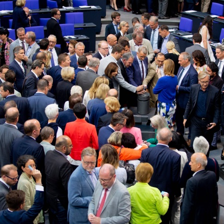 Mitglieder des Deutschen Bundestages stimmen im Plenum im Bundestag an einer Urne zum Asyl- und Aufenthaltsrecht ab.