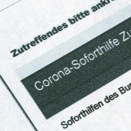 Ein Stift liegt auf einem Antrag für den Corona-Soforthilfe-Zuschuss.