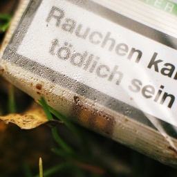 Eine weggeworfene Zigarettenschachtel mit der Aufschrift: "Rauchen kann tödlich sein".