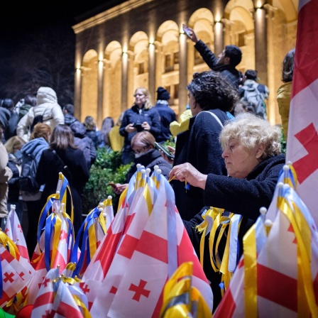 In Tiflis / Georgien verkauft eine Frau bei der Demonstration am 28. Februar 2022 gegen die russische Invasion in der Ukraine georgische Flaggen, die mit Bändern in den Farben der ukrainischen Flagge geschmückt sind. Seit 2008 besetzt Russland Teile Georgiens. Im Frühjahr 2023 demonstrierten die Georgier gegen ihre prorussische Regierung. Der russische Angriffskrieg gegen die Ukraine entscheidet auch über ihre Zukunft.