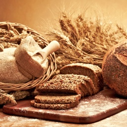 Brot und Getreide auf einem Brett arrangiert.