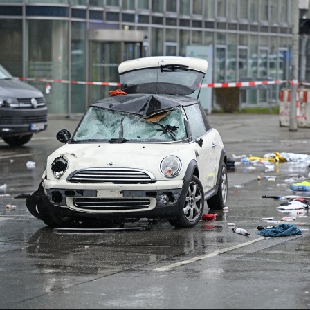 Ein zerstörtes Auto steht auf einer Straße.
