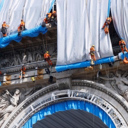 Gebäudekletterer haben mit der Verhüllung des Triumphbogens (Arc de Triomphe) begonnen. Bis zum 18. September 2021 soll die Verhüllung vollendet sein - und damit ein Lebenstraum des Künstler-Ehepaars Christo und Jeanne-Claude, dessen Erfüllung beide jedoch nicht mehr miterleben können.