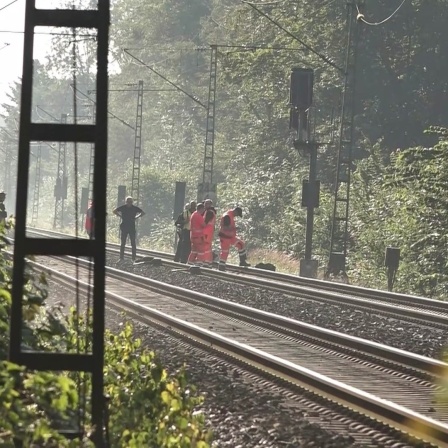 Arbeiter auf Gleisen in Bremen. Zuvor hatte es vermutlich einen Kabelbrand gegeben.