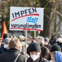 Ein Teilnehmer einer Demonstration hält ein Transparent mit der Aufschrift "Impfen statt verunglimpfen!" auf der Mohrweide am Dammtorbahnhof in Hamburg. 