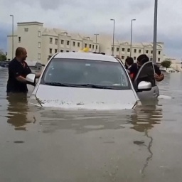 Menschen schieben Auto aus Wasser
