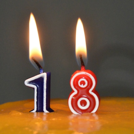 18 Jahre - endlich volljährig. Kerzen mit der Zahl 18 auf einer Geburtstagstorte