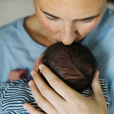 Eine Mutter küsst ihr Baby.