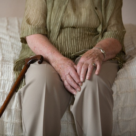 Das Beitragsbild des Dok5 Feature "Einsamkeit" zeigt eine ältere Frau auf dem Bett sitzend.