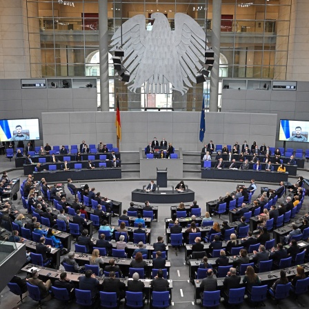 Der ukrainische Präsident Wolodymyr Selenskyj spricht auf Videoleinwänden im Bundestag.