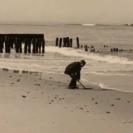 Ein Kind in Kur spielt allein am Strand.