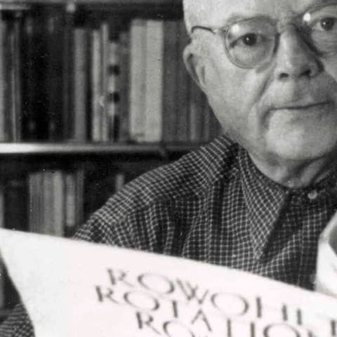 Der Gründer des Rowohlt Verlages, Ernst Rowohlt, blättert in einem seiner Rotationsromane