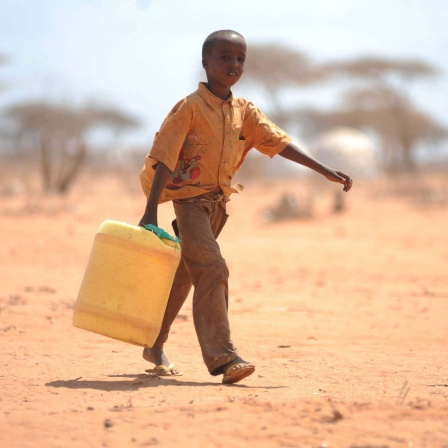 Junge in Somalia trägt einen Kanister mit Wasser. 