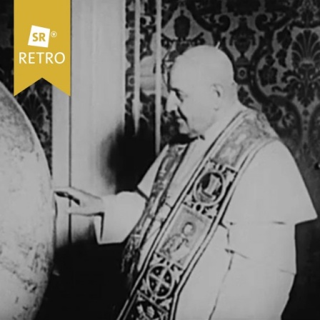Papst Johannes XXIII. steht vor einem großen Globus