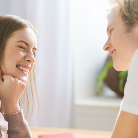 Junge und Mädchen lachen sich an