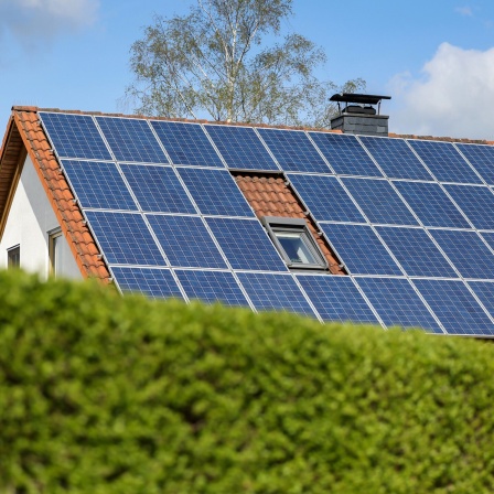 Ein Einfamilienhaus mit Solarpaneelen auf dem Dach