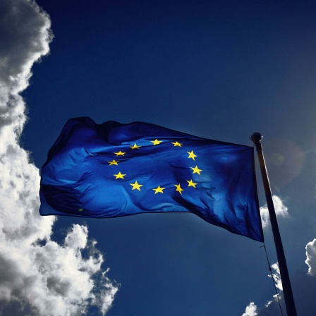 EU-Flagge vor Himmel mit Wolken und Sonne