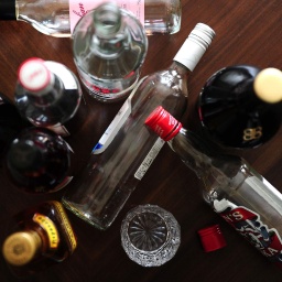 Symbolfoto Alkoholismus: Leere Schnapsflaschen stehen auf dem Boden.