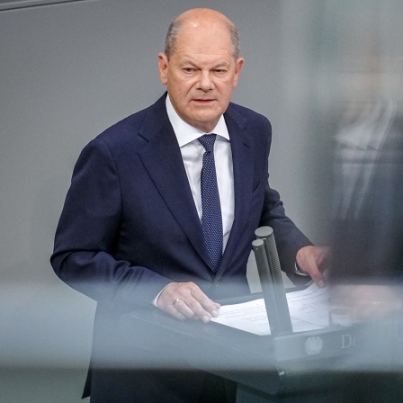 Bundeskanzler Olaf Scholz (SPD) steht an einem Pult und spricht.