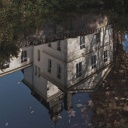 Eine düstere Villa spiegelt sich in dem Wasser eines Sees.