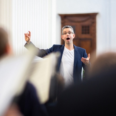 Andreas Reize dirigiert bei einer Chorprobe.