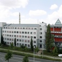 Blick auf das Behördenzentrum im Leipziger Stadtteil Paunsdorf. Weißes längliches Gebäude mit einem roten Gebäudeteil rechts.