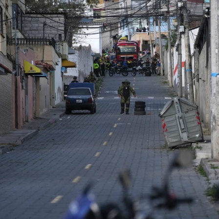 Die Polizei führt in Ecuador eine kontrollierte Explosion eines verdächtigen Fahrzeugs durch, das einen Häuserblock vom Gefängnis El Inca entfernt geparkt ist. (Bild: Carlos Noriega/AP/dpa)