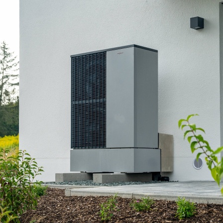 Moderne Wärmepumpe an der Außenwand eines Wohnhauses