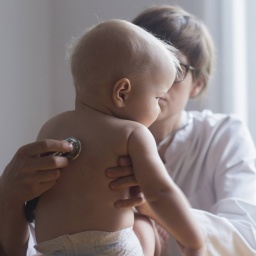 Eine Kinderärztin untersucht einen kleinen Jungen in einer Klinik. Bei den regelmäßigen Früherkennungsuntersuchungen (U1-U9) sprechen Ärzte mit den Eltern auch über anstehende Impfungen.