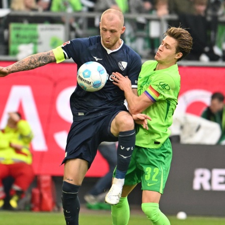 Bochums Philipp Hofmann (M) spielt gegen Wolfsburgs Mattias Svanberg (r) und Wolfsburgs Denis Vavro
