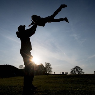 Ein Vater wirft sein Kind in die Luft