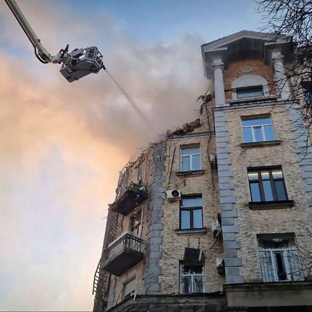 Feuerwehrleute löschen das Feuer in einem beschädigten Gebäude nach einem russischen Drohnenangriff.