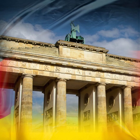 Komposition: Brandenburger Tor in Berlin auf einer Deutschland-Flagge (Bild: IMAGO / Herrmann Agenturfotografie) 