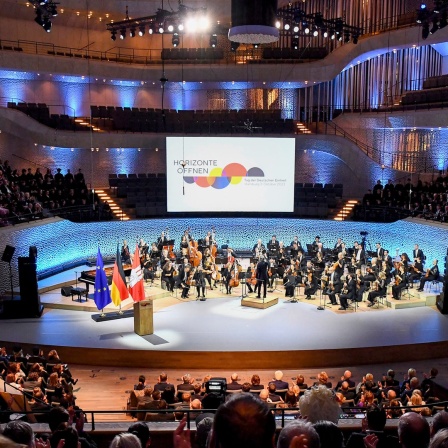 Menschen besuchen einen Festakt anlässlich der Feierlichkeiten zur deutschen Wiedervereinigung in der Elbphilharmonie.