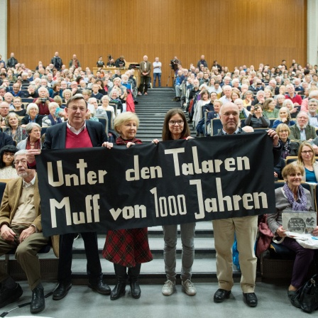 Gert Hinnerk Behlmer (l-r), Bannerträger von 1967, Helga Kutz-Bauer, AStA-Vorsitzende im Sommersemester 1967, Franziska Hildebrandt, AStA-Vorsitzende 2017 und Rainer Nicolaysen, Arbeitsstelle für Universitätsgeschichte halten am 09.11.2017 im Audimax der Universität Hamburg das original Banner aus dem Jahr 1967 mit der Aufschrift